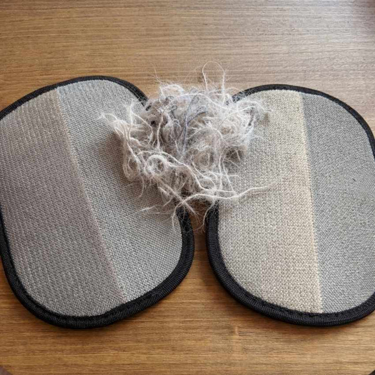 Dos guantes quitapelos sobre mesa de madera